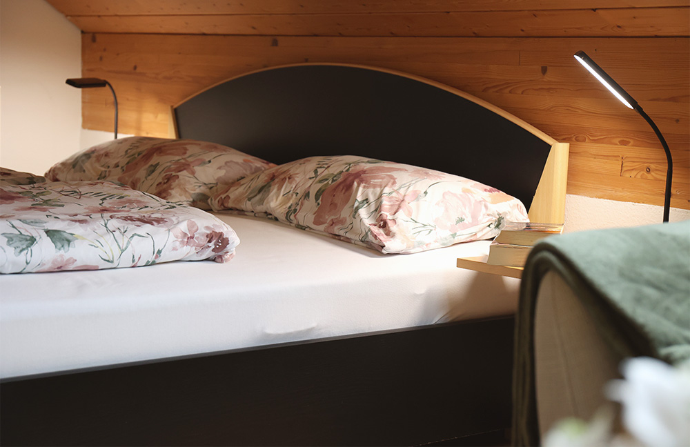 Bett mit Leselicht und Büchern